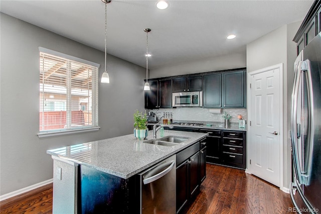 25046 E Bayaud Pl, Aurora, CO 80018 - kitchen featuring appliances with stainless steel finishes, a sink, light stone countertops, dark wood finished floors, and tasteful backsplash