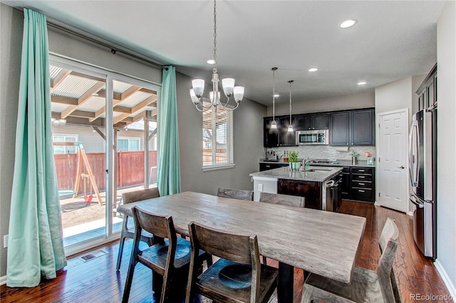 25046 E Bayaud Pl, Aurora, CO 80018 - dining area with dark wood-type flooring, a chandelier, and recessed lighting