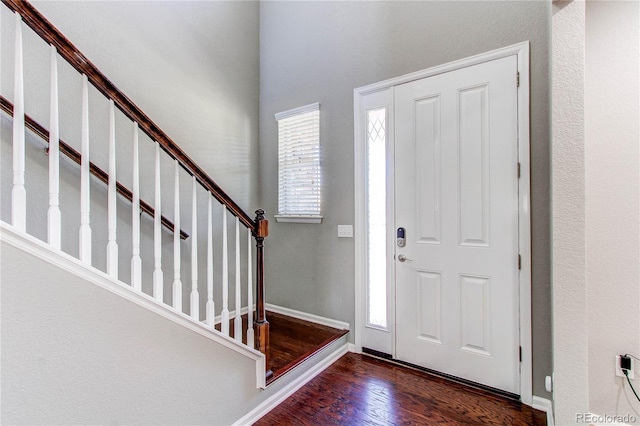 25046 E Bayaud Pl, Aurora, CO 80018 - foyer entrance featuring dark wood-type flooring, stairway, and baseboards