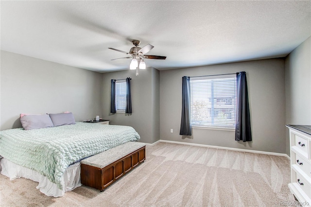 25046 E Bayaud Pl, Aurora, CO 80018 - bedroom with light carpet, multiple windows, baseboards, and a ceiling fan