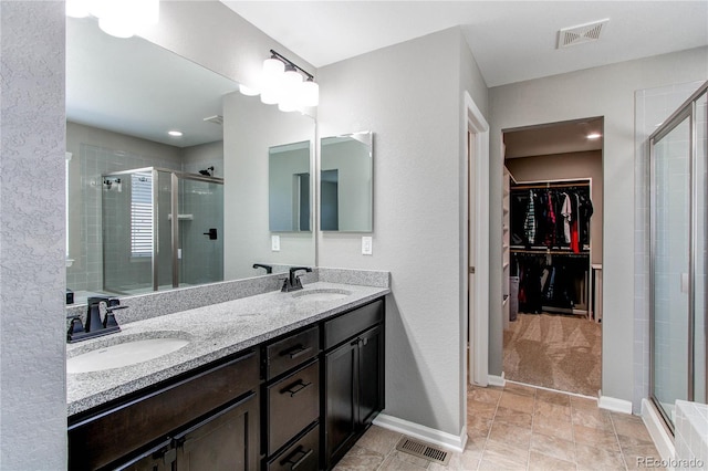 25046 E Bayaud Pl, Aurora, CO 80018 - full bathroom featuring a stall shower, a spacious closet, double vanity, and baseboards