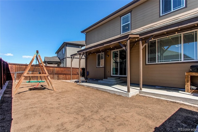 25046 E Bayaud Pl, Aurora, CO 80018 - rear view of house featuring a fenced backyard, a playground, and a patio area