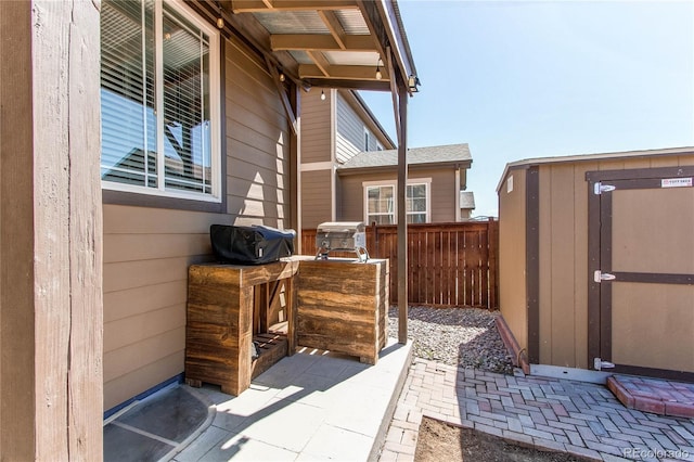 25046 E Bayaud Pl, Aurora, CO 80018 - view of patio with fence, an outdoor structure, a shed, and area for grilling
