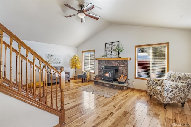 living room with ceiling fan, lofted ceiling, and light hardwood / wood-style floors