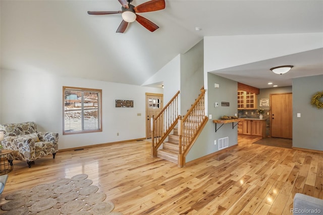 living room featuring light wood-type flooring, lofted ceiling, and ceiling fan