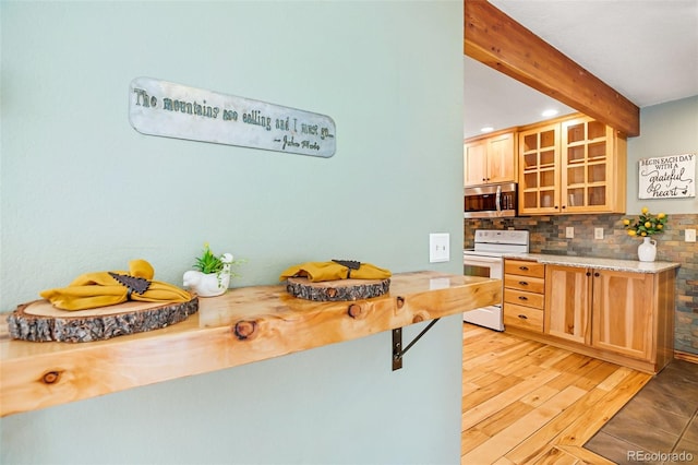 kitchen featuring beam ceiling, light brown cabinetry, light hardwood / wood-style floors, white electric range oven, and backsplash