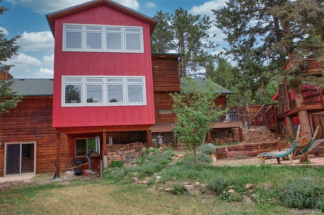 back of property featuring a lawn and a deck