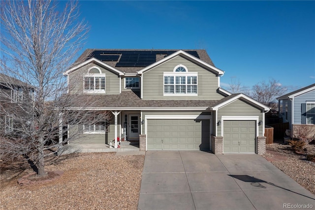 view of property featuring solar panels, a garage, and covered porch