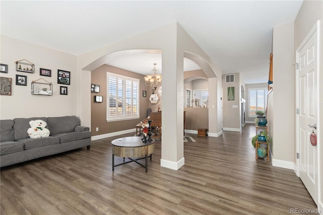 living room with dark hardwood / wood-style flooring and a notable chandelier