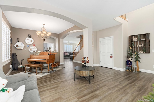 living room featuring wood-type flooring and ceiling fan with notable chandelier