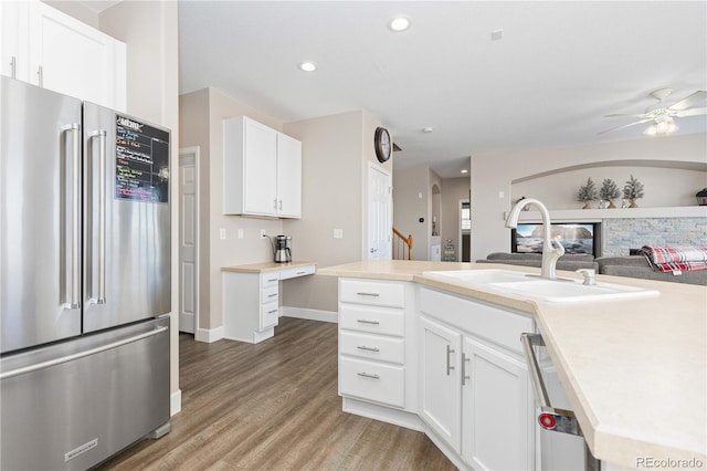 kitchen featuring stainless steel appliances, ceiling fan, sink, hardwood / wood-style flooring, and white cabinets