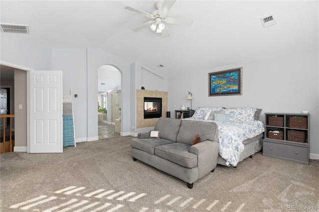 carpeted bedroom with ceiling fan, lofted ceiling, and a fireplace