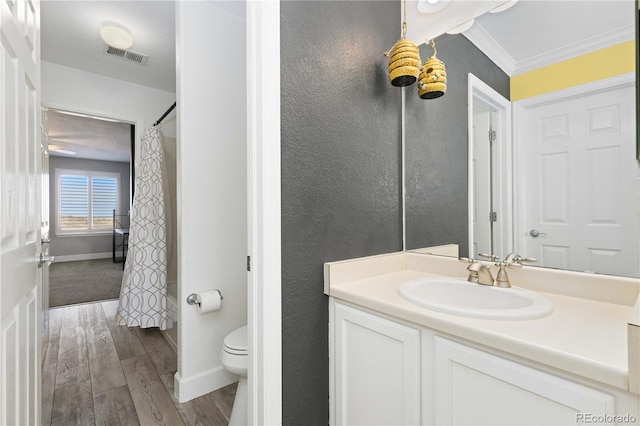 full bathroom featuring vanity, shower / bath combination with curtain, crown molding, hardwood / wood-style flooring, and toilet