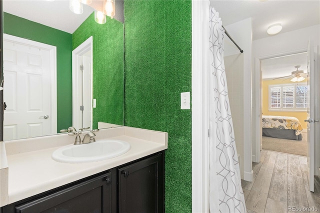 bathroom featuring ceiling fan, hardwood / wood-style floors, and vanity