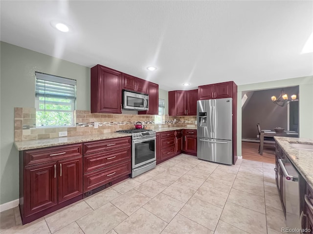 7085 Kiowa Rd, Larkspur, CO 80118 - kitchen featuring stainless steel appliances, reddish brown cabinets, backsplash, light stone countertops, and recessed lighting