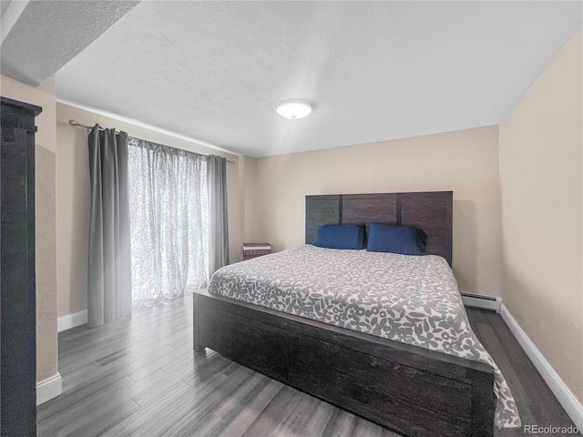 7085 Kiowa Rd, Larkspur, CO 80118 - bedroom with a baseboard heating unit, wood finished floors, and a textured ceiling