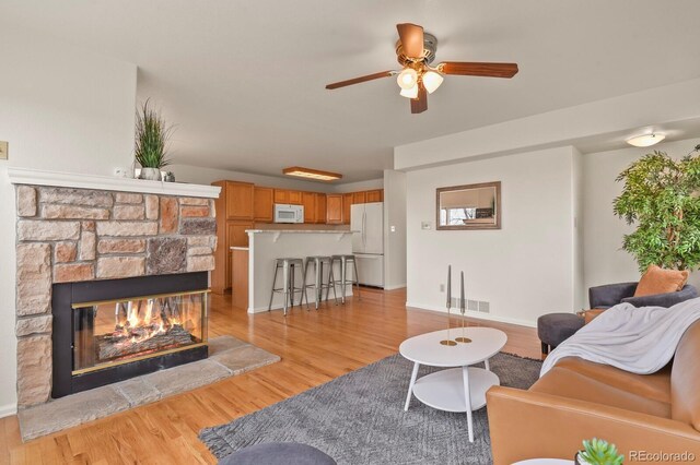 3244 Capstan Way, Colorado Springs, CO 80906 - living room featuring ceiling fan, a fireplace, and light wood-type flooring