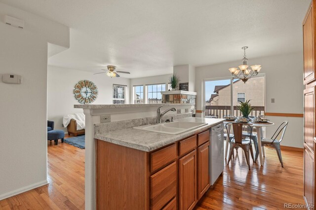 3244 Capstan Way, Colorado Springs, CO 80906 - kitchen with ceiling fan with notable chandelier, sink, hanging light fixtures, white dishwasher, and light hardwood / wood-style floors