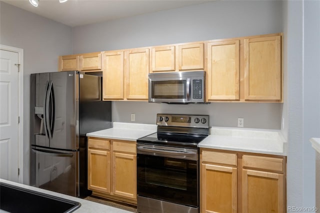 4451 S Ammons St Unit 2-204, Littleton, CO 80123 - kitchen with appliances with stainless steel finishes, light brown cabinetry, and light countertops