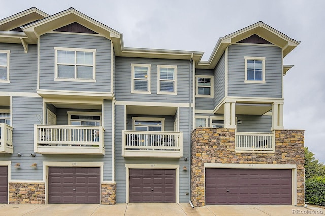 9381 Ashbury Cir Unit 105, Parker, CO 80134 - townhome / multi-family property featuring an attached garage, stone siding, and driveway