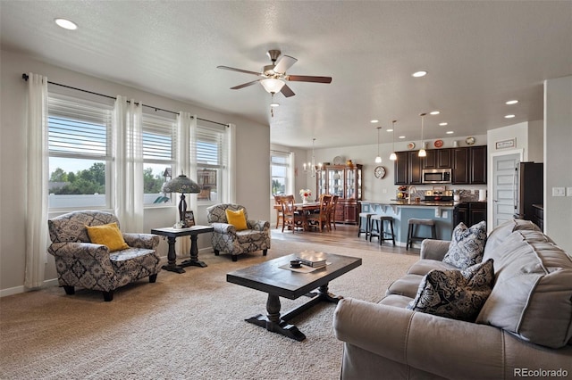 2200 Cadman St, Berthoud, CO 80513 - living area featuring a ceiling fan, light colored carpet, recessed lighting, and a chandelier