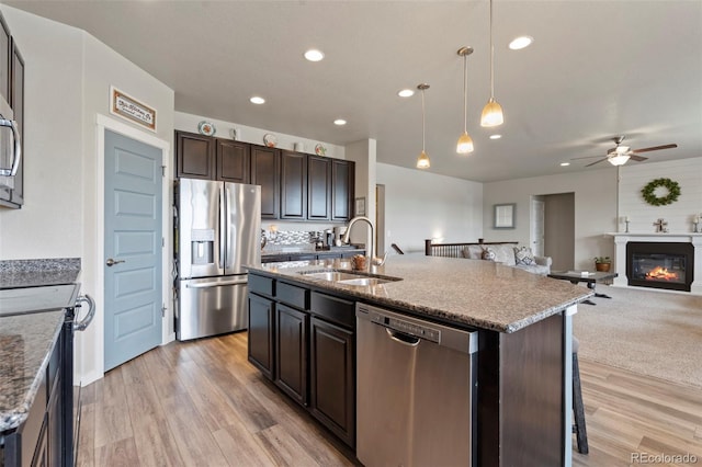 2200 Cadman St, Berthoud, CO 80513 - kitchen with appliances with stainless steel finishes, a sink, a ceiling fan, open floor plan, and light wood-style floors