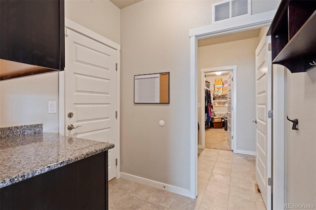 2200 Cadman St, Berthoud, CO 80513 - kitchen with baseboards, dark brown cabinets, light tile patterned flooring, and light stone countertops