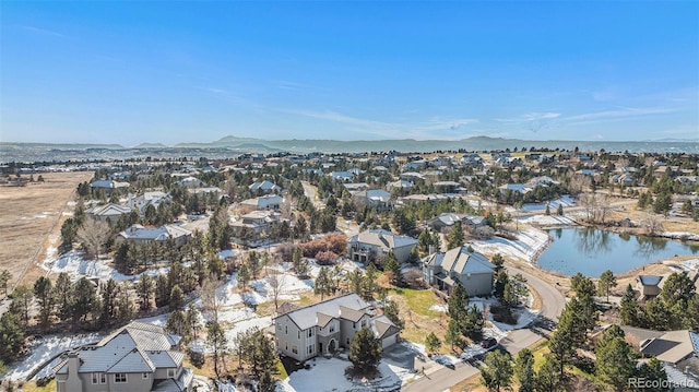 drone / aerial view featuring a water and mountain view