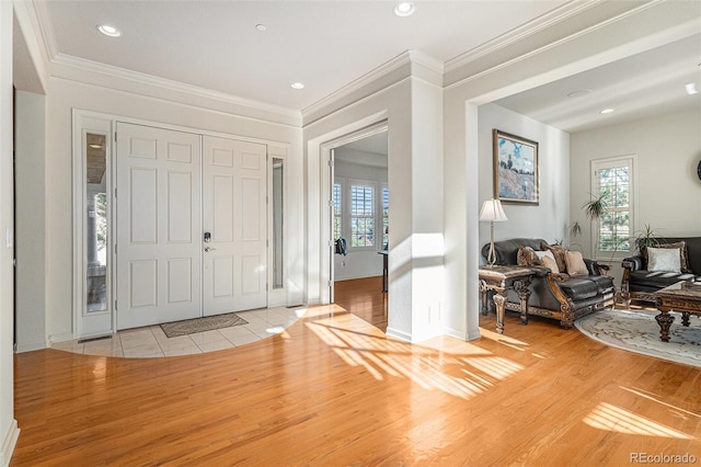 entrance foyer with crown molding and light hardwood / wood-style floors