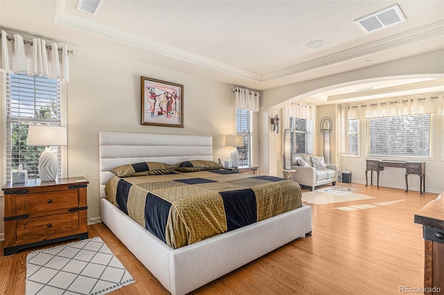 bedroom featuring a tray ceiling and wood-type flooring