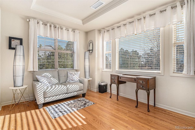 sitting room featuring a raised ceiling, crown molding, and light hardwood / wood-style floors