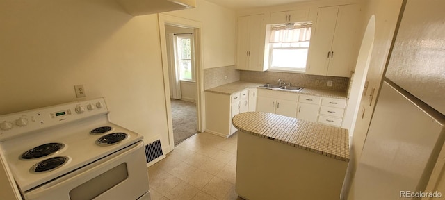 9120 Elm Ct, Denver, CO 80260 - kitchen featuring white range with electric stovetop, light countertops, backsplash, white cabinets, and light floors