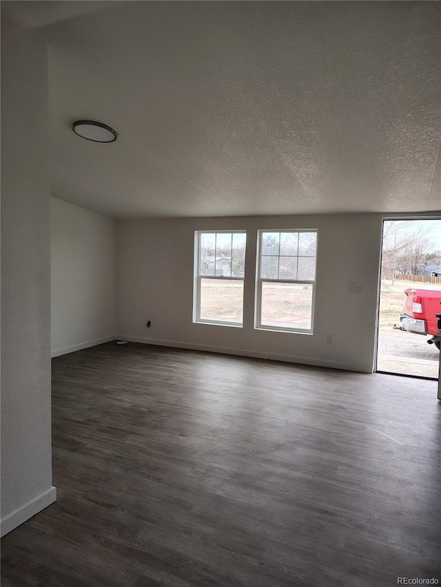 7486 Harold St, Fort Lupton, CO 80621 - spare room with dark wood-style floors, baseboards, and a textured ceiling