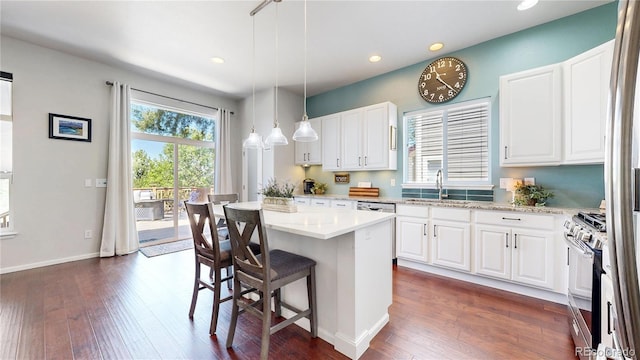 kitchen featuring stainless steel appliances, a breakfast bar, dark wood-type flooring, recessed lighting, and a sink