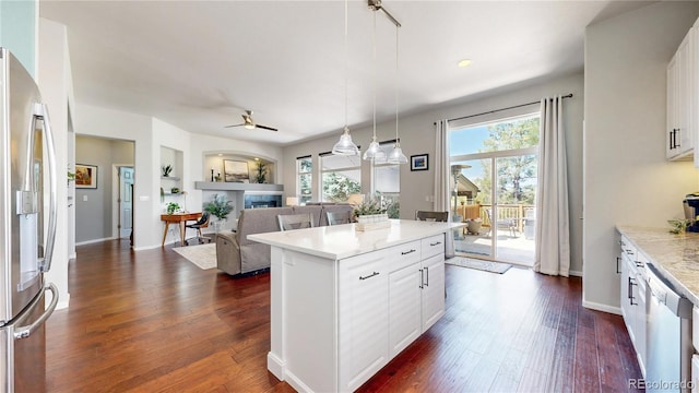kitchen featuring stainless steel fridge, ceiling fan, plenty of natural light, and a fireplace