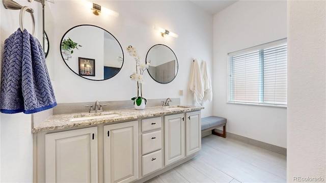 bathroom with double vanity and baseboards