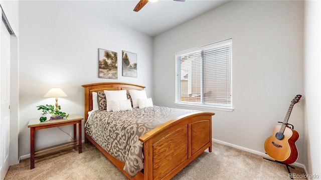 bedroom featuring light colored carpet, baseboards, a ceiling fan, and a closet