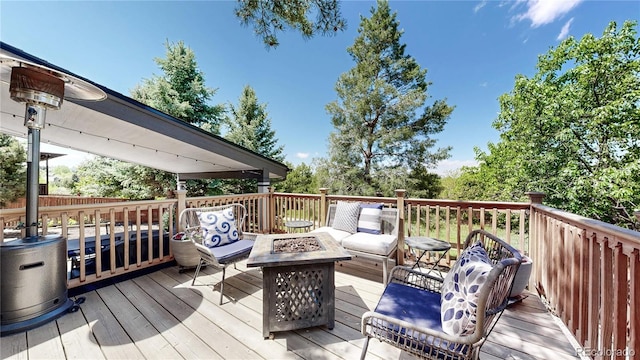 wooden terrace with an outdoor living space with a fire pit