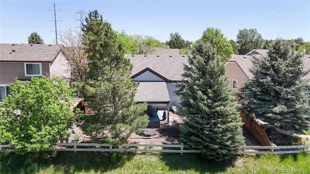 rear view of house with fence and roof with shingles