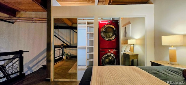 bedroom featuring beamed ceiling, stacked washer and dryer, and wooden ceiling