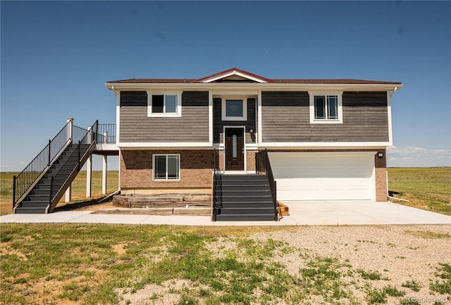 38810 Jacobson Rd, Rush, CO 80833 - view of front facade featuring driveway, a garage, stairs, and brick siding
