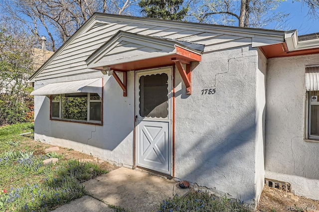 entrance to property featuring stucco siding