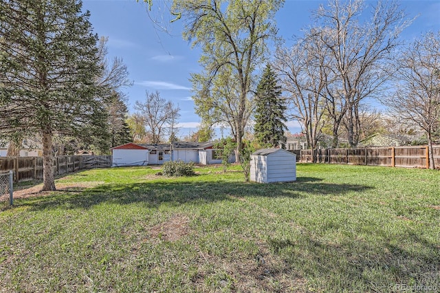 view of yard featuring an outbuilding, a storage unit, and a fenced backyard