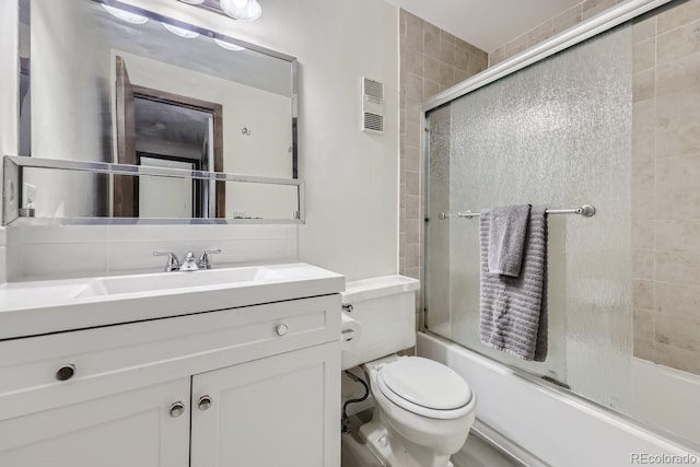 full bathroom with shower / bath combination with glass door, vanity, and toilet