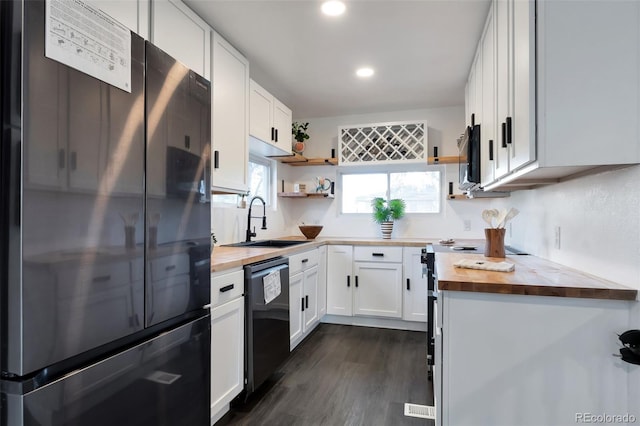 kitchen featuring black appliances, butcher block counters, dark hardwood / wood-style floors, and white cabinets