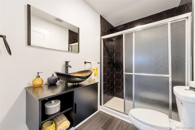 bathroom with a shower with door, toilet, wood-type flooring, and vanity