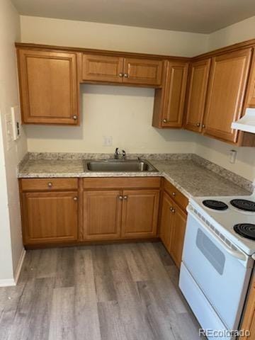 kitchen featuring white electric range oven, light stone countertops, hardwood / wood-style flooring, extractor fan, and sink