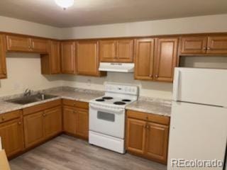 kitchen with sink, range hood, light wood-type flooring, and white appliances