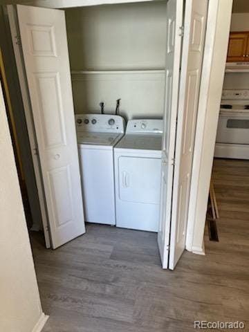 washroom with washing machine and dryer and hardwood / wood-style floors