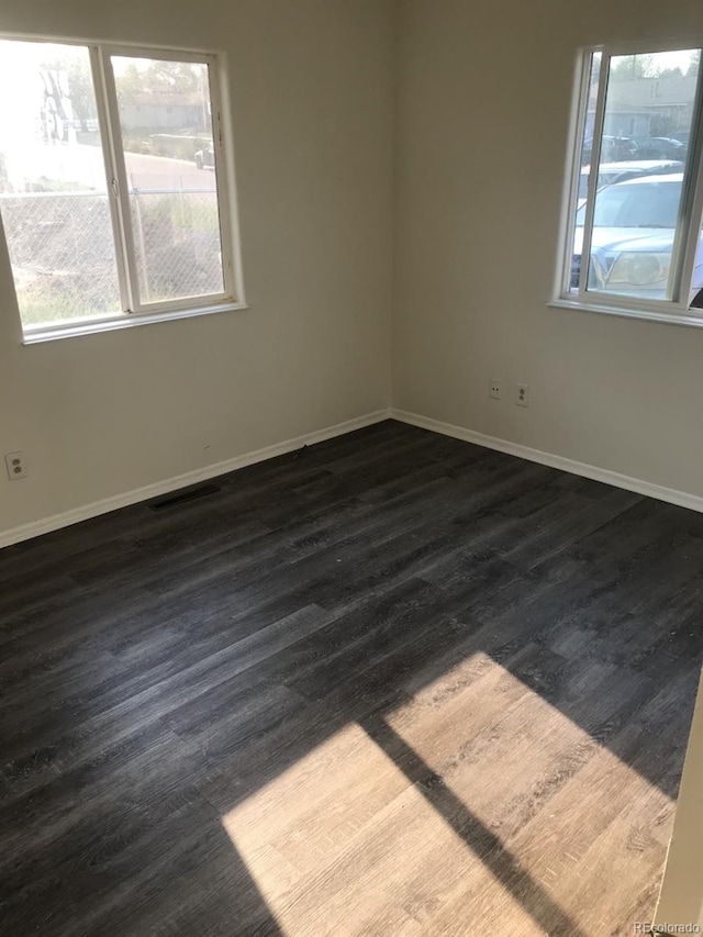 spare room featuring hardwood / wood-style flooring and plenty of natural light